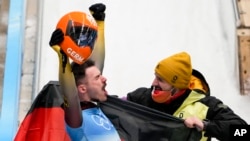 Axel Jungk, of Germany, celebrates winning the silver medal in the men's skeleton at the 2022 Winter Olympics, Feb. 11, 2022