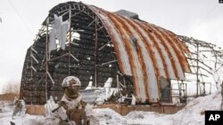 Un militar ucraniano brinda seguridad en el área durante una visita del general Oleksandr Pavliuk, comandante de la Operación de Fuerzas Conjuntas, en una antigua área industrial, en las afueras de Avdiivka, región de Donetsk, este de Ucrania, el 9 de febrero de 2022.