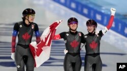 Team Canada's Isabelle Weidemann, left, Valerie Maltais and Ivanie Blondin, right, celebrate after they won the gold medal and set an Olympic record in the speedskating women's team pursuit finals at the 2022 Winter Olympics, Feb. 15, 2022.