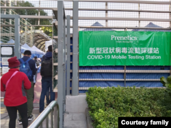 港府坚持以“动态清零”作为抗疫方向。人们在香港的一个流动新冠病毒采样站前排队等候检测。