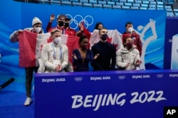 FILE - Vanessa James and Eric Radford, of Canada, react after the pairs team free skate program during the figure skating competition at the 2022 Winter Olympics, Feb. 7, 2022, in Beijing.