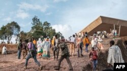 Les milices amhara marchent à travers une foule de pèlerins avec leurs fusils, début 2022. 