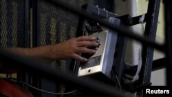 FILE - A death row inmate uses a phone from his cell in at San Quentin State Prison in San Quentin, Calif. Dec. 29, 2015. 