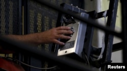 FILE - A death row inmate uses a phone from his cell in at San Quentin State Prison in San Quentin, Calif. Dec. 29, 2015. 