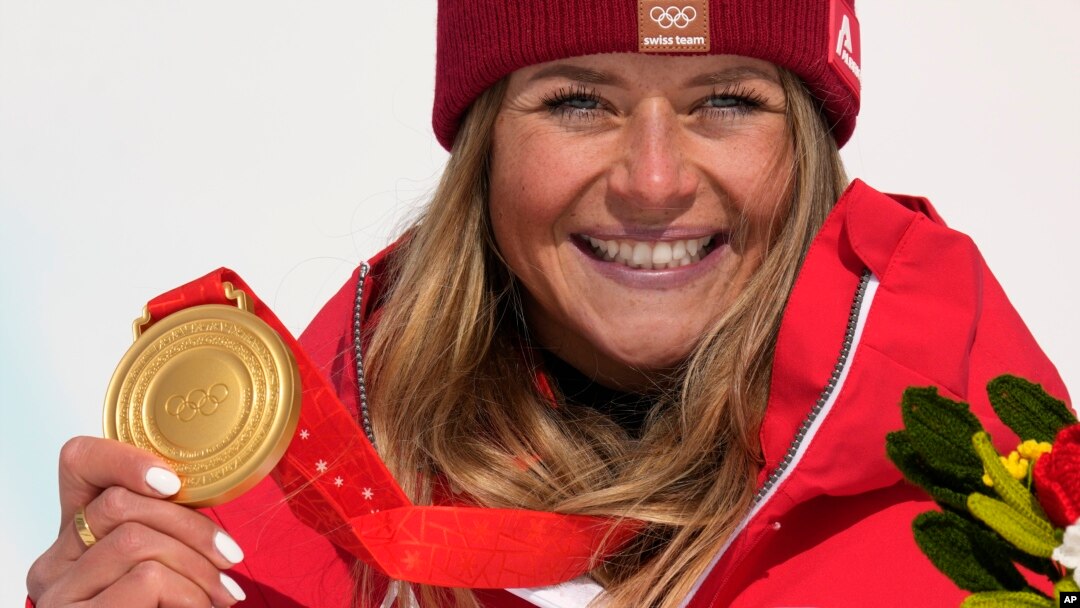 Gold medalist Corinne Suter of Switzerland celebrates during the medal ceremony for the women's downhill at the 2022 Winter Olympics, Feb. 15, 2022.