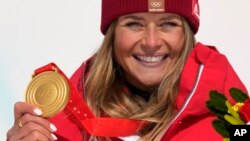 Gold medalist Corinne Suter of Switzerland celebrates during the medal ceremony for the women's downhill at the 2022 Winter Olympics, Feb. 15, 2022.