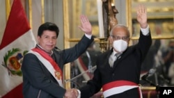 Presiden Peru Pedro Castillo (kiri) dan Kepala Kabinet barunya Anibal Torres, melambaikan tangganya saat pengambilan sumpah Kabinet baru di istana pemerintah di Lima, Peru, Selasa, 8 Februari 2022. (Foto AP/Martin Mejia)