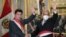 Presiden Peru Pedro Castillo (kiri) dan Kepala Kabinet barunya Anibal Torres, melambaikan tangganya saat pengambilan sumpah Kabinet baru di istana pemerintah di Lima, Peru, Selasa, 8 Februari 2022. (Foto AP/Martin Mejia)