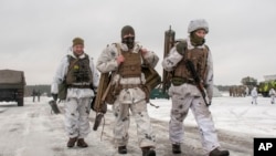 Ukrainian soldiers walk during military drills near Kharkiv, Ukraine, close to the country's border with Russia, Feb. 10, 2022.