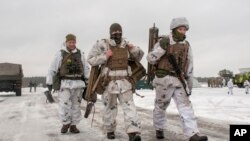 Ukrainian soldiers walk during military drills near Kharkiv, Ukraine, close to the country's border with Russia, Feb. 10, 2022.