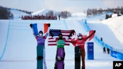 From left silver medalist France's Chloe Trespeuch, gold medalist United States' Lindsey Jacobellis and bronze medalist Canada's Meryeta O'Dine celebrate during the venue ceremony for the women's snowboard cross at the 2022 Winter Olympics, Wednesday, Feb. 9, 2022, in Zhangjiakou, China. (AP Photo/Lee Jin-man)