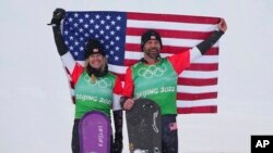 Gold medal winners United States' Lindsey Jacobellis and Nick Baumgartner celebrate during the venue award ceremony for the mixed team snowboard cross finals at the 2022 Winter Olympics, Feb. 12, 2022, in Zhangjiakou, China.