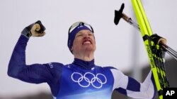 Iivo Niskanen, of Finland, celebrates after winning the men's 15km classic cross-country skiing competition at the 2022 Winter Olympics, Feb. 11, 2022.