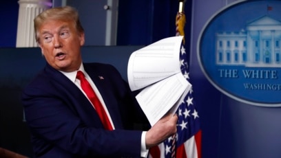 Mantan Presiden AS Donald Trump menunjukkan dokumen dalam sebuah konferensi pers di Gedung Putih, Washington, ketika ia masih menjabat pada 20 April 2020. (Foto: AP/Alex Brandon)