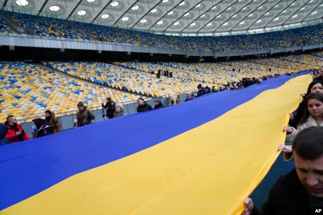 A 200-meter-long Ukrainian flag is unfolded during a Day of Unity event, at the Olympiyskiy stadium in Kyiv, Ukraine, Feb. 16, 2022.