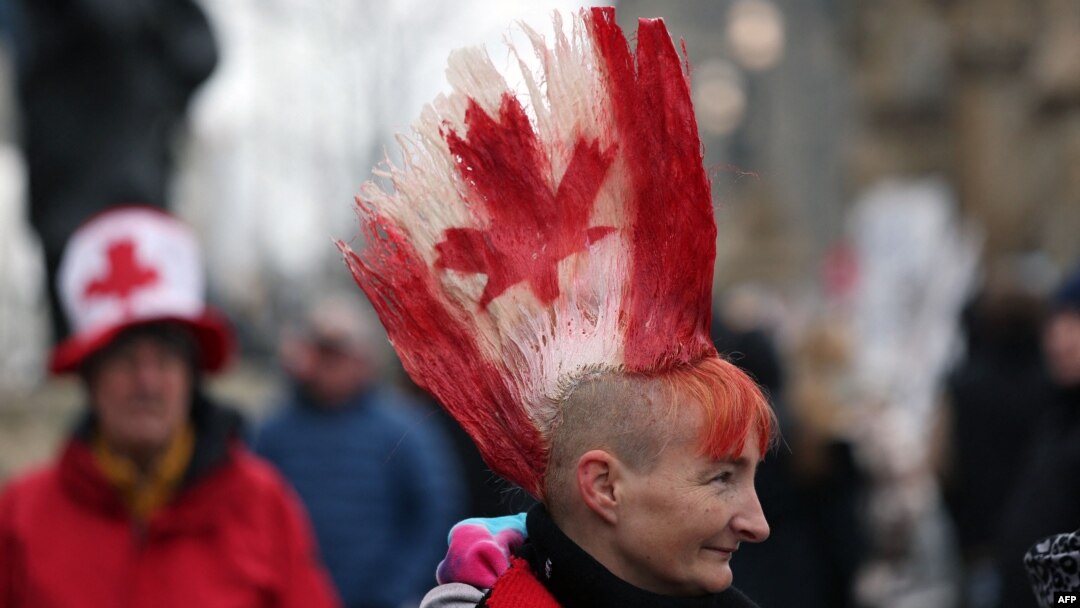 A protester with a Canadian flag painted in her hair walks the line as demonstrators continue to protest the COVID-19 mandates on Feb. 10, 2022 in Ottawa, Canada.