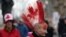 A protester with a Canadian flag painted in her hair walks the line as demonstrators continue to protest the COVID-19 mandates on Feb. 10, 2022 in Ottawa, Canada.
