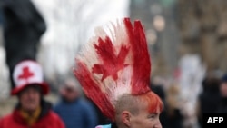 FILE - A protester with a Canadian flag painted in her hair walks the line as demonstrators continue to protest the COVID-19 mandates on Feb. 10, 2022, in Ottawa, Canada.