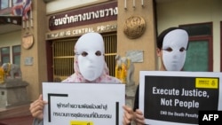 FILE - Activists from the Amnesty International display placards during a protest at the entrance of the Bang Kwang high-security prison in Nonthaburi in the outskirts of Bangkok, June 19, 2019.