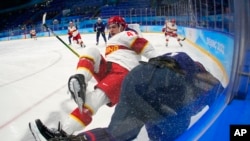 中国男子冰球队的球员建安(Cory Kane)在北京冬奥会男子冰球小组赛中与美国队的安迪·米尔(Andy Miele)相撞。(2022年2月10日)