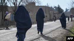 Para perempuan mengenakan burqa saat berjalan di Balkh, di sebelah barat laut dari Mazar-i-Sharif, Afghanistan, pada 22 Desember 2021. (Foto: AFP/Mohd Rasfan)