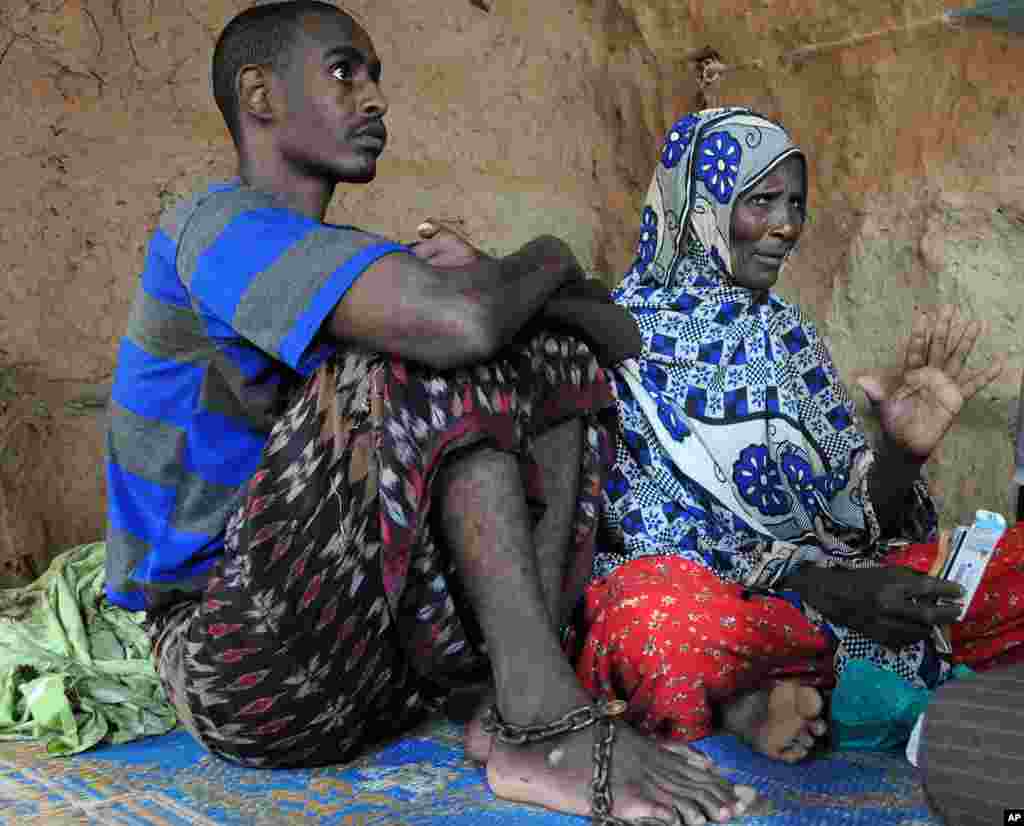 Siyad Abdi Ali, 24, with his mother at the refugee camp. Ali developed an unidentified mental illness after he was allegedly tortured by Ethiopian troops before coming to the camps. His family keeps him restrained to prevent him from harming himself. (VOA