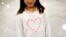 FILE - Janet Mejia, 7, wears a sweater bearing a heart as she waits for two siblings to arrive from El Salvador in Linthicum, Md., Nov. 12, 2015. They were among the first teens to receive permission to travel legally to the U.S. via the Central American Minors program.