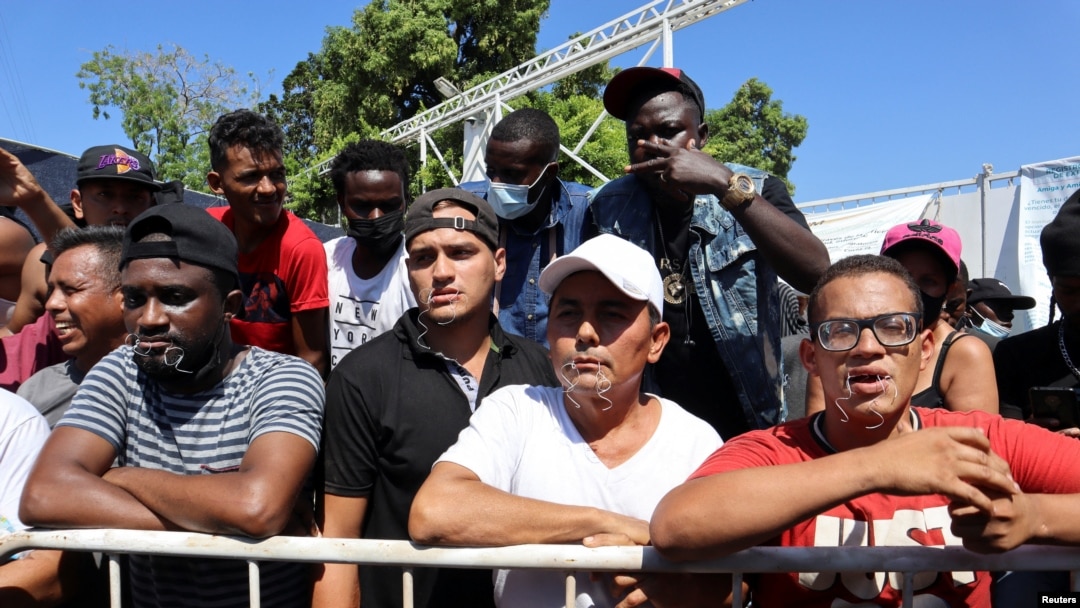 Para migran memulai aksi mogok makan dengan mulut dijahit di luar kantor Institut Migrasi Nasional (INM) di Tapachula, Meksiko, 15 Februari 2022. (REUTERS/Jose Torres) MATERI SENSITIF. 