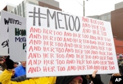 Seorang pengunjuk rasa membawa tanda dengan tagar Twitter #MeToo yang digunakan oleh orang-orang yang menentang pelecehan seksual, selama pawai perempuan di Seattle, 20 Januari 2018. (Foto: AP)