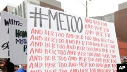 FILE - A marcher carries a sign with the Twitter hashtag #MeToo, used by people speaking out against sexual harassment, during a march in Seattle, Jan. 20, 2018. Congress on Feb. 10, 2022, approved legislation guaranteeing that people who experience sexual harassment at work can seek recourse in the courts.