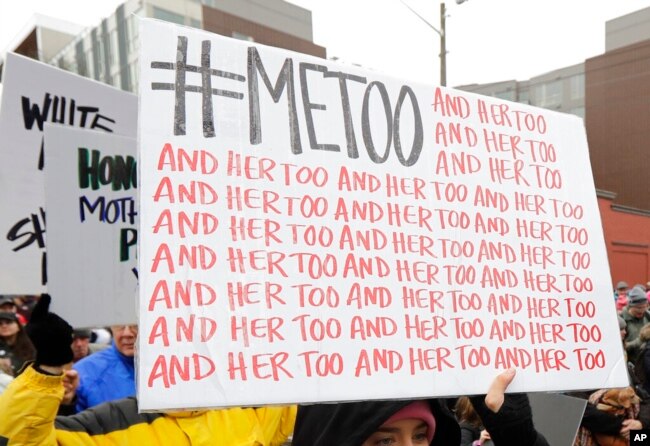 Seorang pengunjuk rasa membawa tanda dengan tagar Twitter #MeToo yang digunakan oleh orang-orang yang menentang pelecehan seksual, selama pawai perempuan di Seattle, 20 Januari 2018. (Foto: AP)