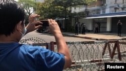 FILE - A journalist and a police officer take pictures of each other as people protest against the military coup in Yangon, Myanmar, Feb. 23, 2021. Journalists reporting on the resistance movement are often forced to work underground or in exile to avoid arrest or retaliation.