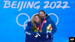 Gold medalists Lindsey Jacobellis, Nick Baumgartner celebrate during medal ceremony for mixed team snowboard cross at the 2022 Winter Olympics, Beijing, Feb. 12, 2022.