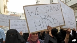 Indian Muslim woman holds placards during a protest against banning Muslim girls wearing hijab from attending classes at some schools in the southern Indian state of Karnataka, in Hyderabad, India, Feb. 11, 2022.