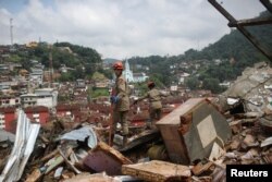 Orang-orang bekerja di lokasi tanah longsor di Morro da Oficina setelah hujan lebat di Petropolis, Brazil, 16 Februari 2022. (Foto: REUTERS/Ricardo Moraes)