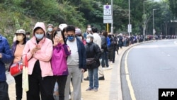 香港市民排長隊等候進行新冠病毒核酸檢測。 （2022年2月10日）