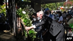 El encargado de negocios de la embajada de Estados Unidos en El Salvador, Brendan O'Brien, coloca una ofrenda floral durante la conmemoración del 40 aniversario de una masacre en El Mozote, 200 km al este de San Salvador, el 11 de diciembre de 2021.