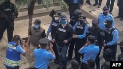 Imagen tomada de un video de la policía de Honduras al momento que se llevan detenido al expresidente Juan Orlando Hernández. Foto: AFP
