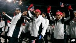 FILE - Michelle Kwan, far right, Vonetta Flowers, center, and Randy Jones, left, arrive with the United States team during the opening ceremony for the 2006 Winter Olympics in Turin, Italy, Feb. 10, 2006. 