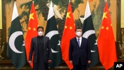 FILE - In this photo released by Xinhua News Agency, Chinese President Xi Jinping, right, and Pakistan Prime Minister Imran Khan pose for a photo before their bilateral meeting at the Great Hall of the People in Beijing, Feb. 6, 2022. 