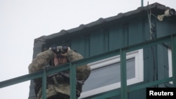 A member of the Ukrainian State Border Guard Service keeps watch at the Kliusy checkpoint near the frontier with Russia in the Chernihiv region, Ukraine, Feb. 16, 2022.