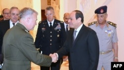 FILE - A handout picture released by the Egyptian Presidency June 11, 2019, shows Egyptian President Abdel Fattah el-Sissi (C-R) shaking hands with the head of U.S. Central Command, Marine Corps General Kenneth F. McKenzie Jr., at the presidential palace