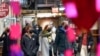 FILE - Shoppers wear masks while walking through an indoor market in New York City on Feb. 9, 2022.