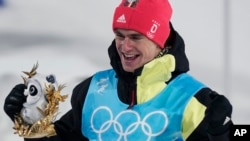 Gold medal finisher Germany's Vinzenz Geiger celebrates after the cross-country skiing portion of the individual Gundersen normal hill/10km event at the 2022 Winter Olympics, Feb. 9, 2022, in Zhangjiakou, China.