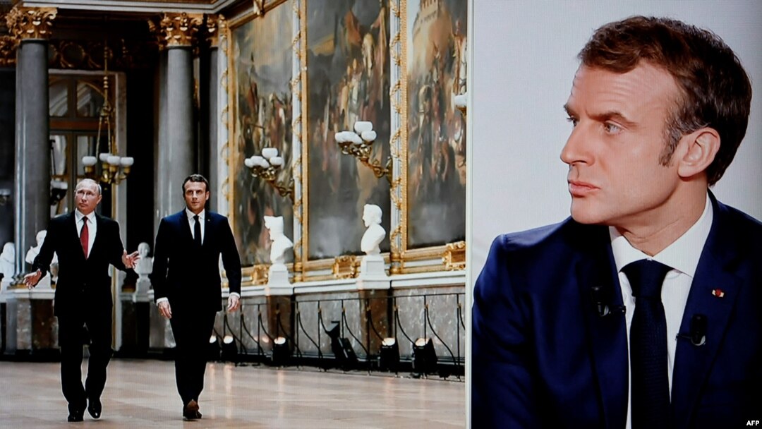 Una fotografía tomada el 15 de diciembre de 2021 muestra una pantalla de televisión que transmite el canal de televisión francés TF1 mientras el presidente francés Emmanuel Macron mira una imagen en que aparece con el presidente ruso Vladimir Putin. [Foto de Ludovic MARIN / AFP]