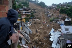 Regu penyelamat dan penduduk melakukan pencarian korban di daerah yang terkena tanah longsor di Petropolis, Brasil, Rabu, 16 Februari 2022. (AP/Silvia Izquierdo)