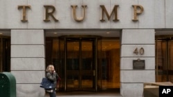 FILE - A woman walks past the Trump Building in New York's financial district, Jan. 13, 2021. 