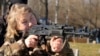 A woman practices using a Kalashnikov assault rifle as members of a Ukrainian far-right group train, in Kyiv, Ukraine, Feb. 13, 2022. 