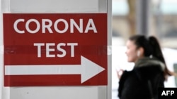 A sign points to a coronavirus testing center in Essen, western Germany, Feb. 16, 2022.