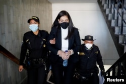 Lawyer Eva Siomara Sosa, who worked at the Special Prosecutor's Office against Impunity (FECI), is escorted by police officers at the Supreme Court of Justice building, in Guatemala City, Guatemala, Feb. 15, 2022.